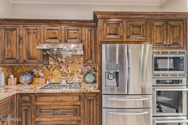 a kitchen with stainless steel appliances granite countertop a refrigerator and a stove