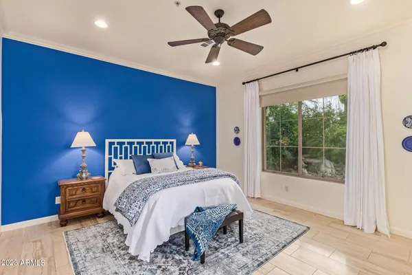 a bed sitting in a spacious bedroom next to a window