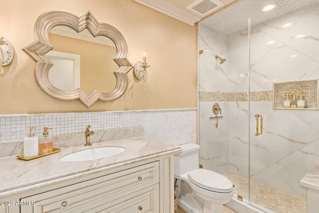 a bathroom with a sink a toilet and shower