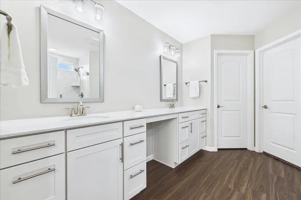a spacious bathroom with double vanity sink a two mirror a window and vanity