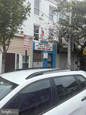 a front view of a building with grey trees