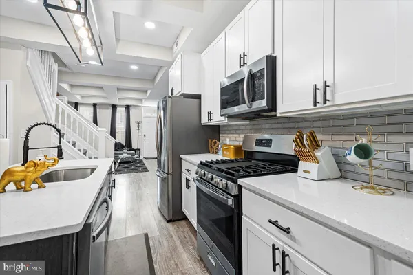 a kitchen with stainless steel appliances a stove a sink a stove and a refrigerator