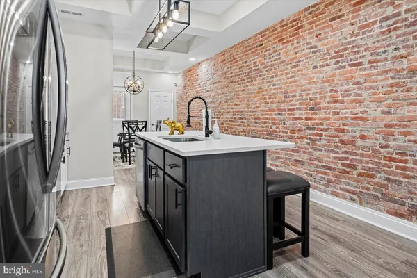 a kitchen with a sink a refrigerator and wooden floor
