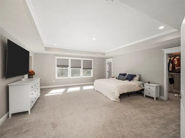 a spacious bedroom with a bed and a flat screen tv