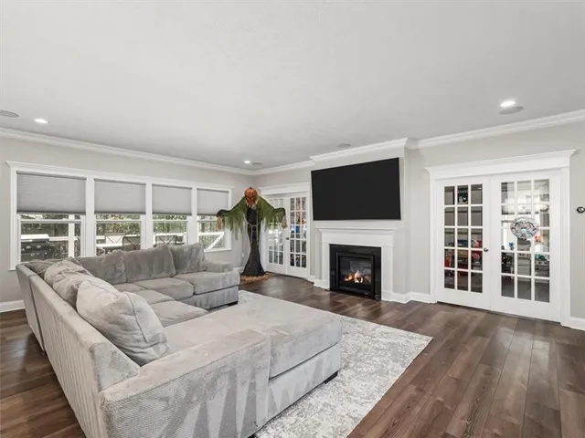 a living room with furniture a fireplace and a floor to ceiling window