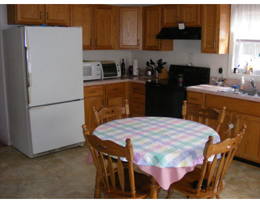 32 Evergreen Road Natick, MA 01760 - Photo 9 of 24 a kitchen with stainless steel appliances kitchen island granite countertop a refrigerator a stove a sink a dining table and chairs with wooden floor