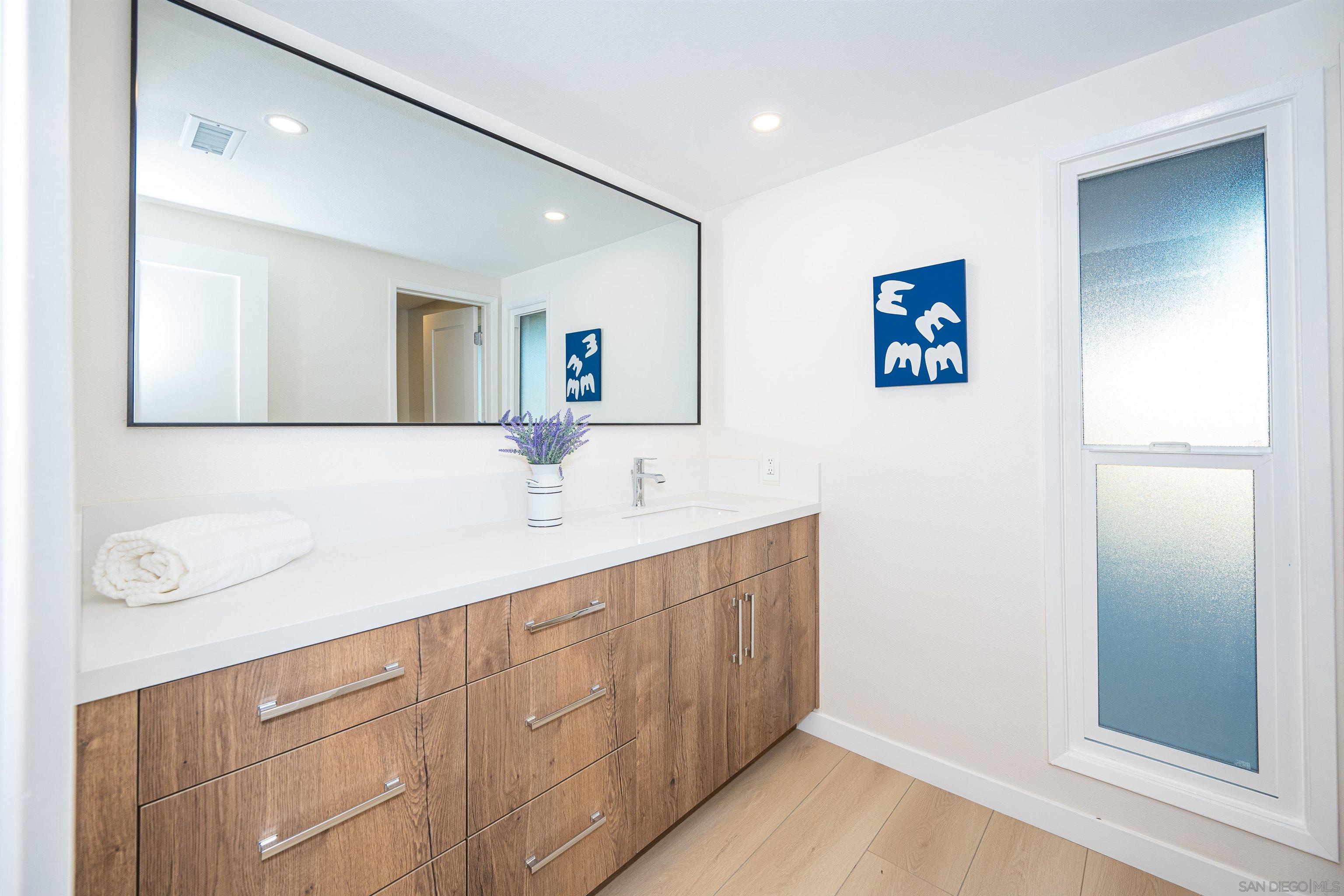 1360 Elevation Road San Diego, CA 92110 - Photo 27 of 37 a bathroom with a sink a mirror and a shower