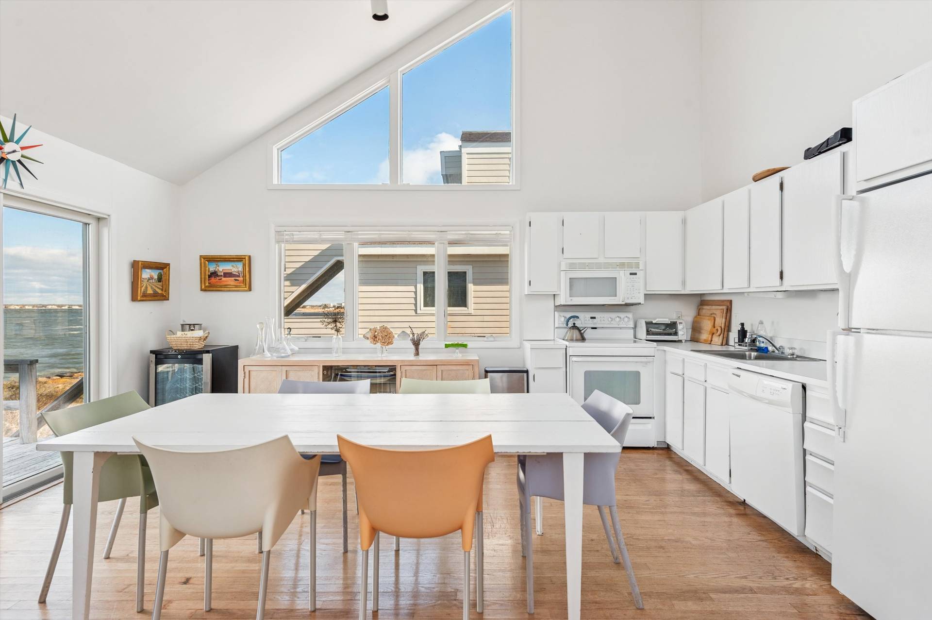 630 Dune Road Westhampton, NY 11978 - Photo 4 of 14 a kitchen with a dining table chairs and white appliances