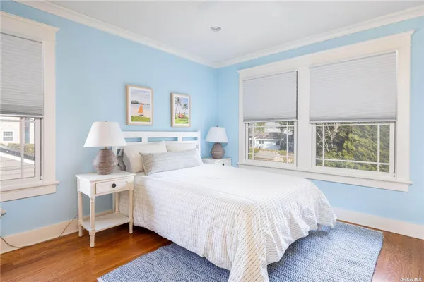 a bedroom with a large bed and wooden floor