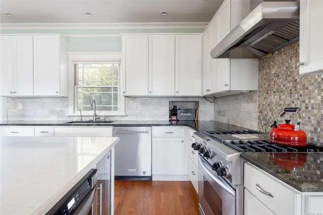 a kitchen with stainless steel appliances granite countertop a stove sink and cabinets