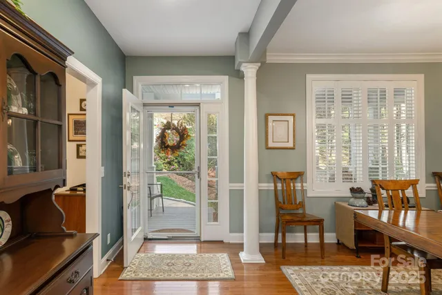 a dining room with wooden floor a chandelier a wooden table and chairs
