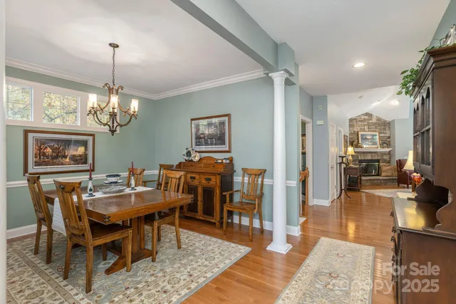 a view of a dining room with furniture a rug and wooden floor