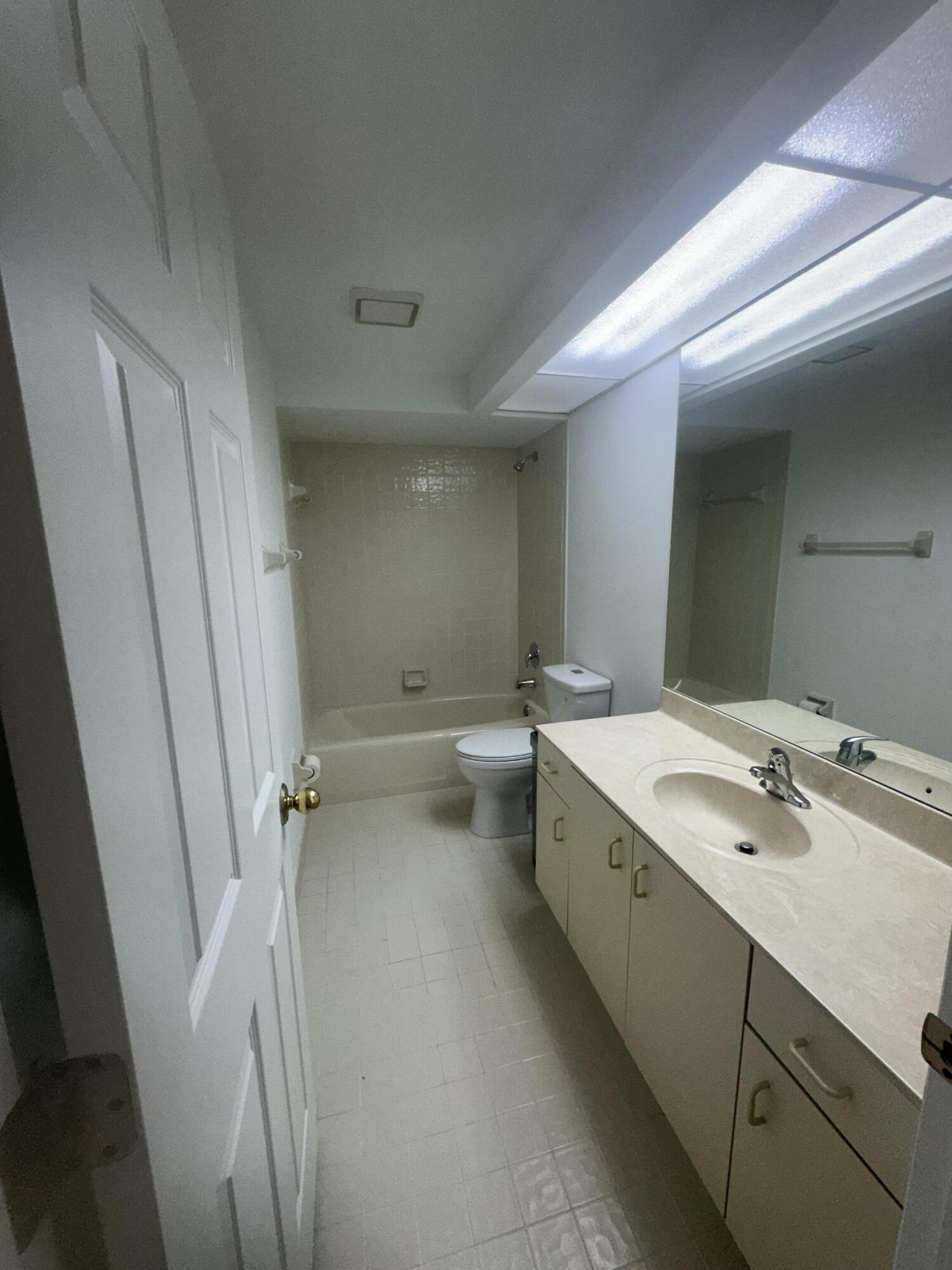 5270 Southeast Seascape Way, Unit 102 Stuart, FL 34997 - Photo 15 of 24 a bathroom with a double vanity sink and mirror with toilet