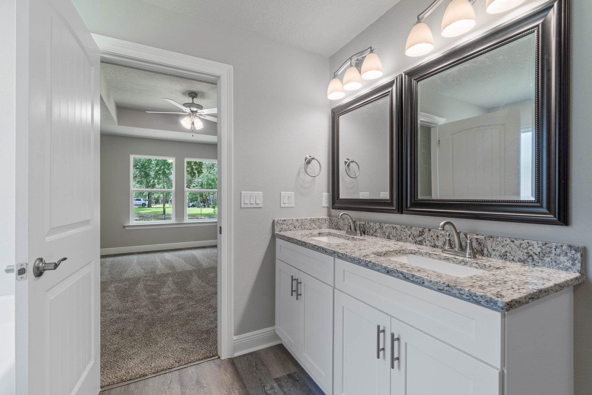 9194 Trident Road Milton, FL 32583 - Photo 23 of 45 a bathroom with a granite countertop sink a large mirror and a vanity