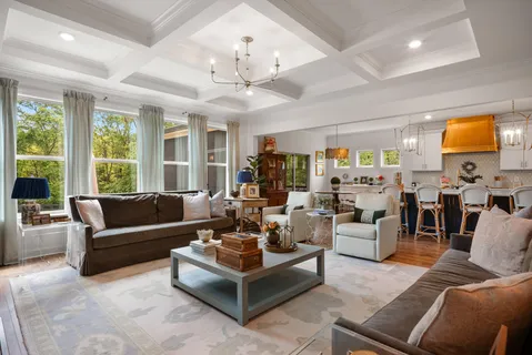 a living room with furniture a flat screen tv and a floor to ceiling window