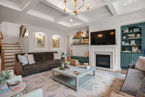 a living room with furniture a fireplace and a large window
