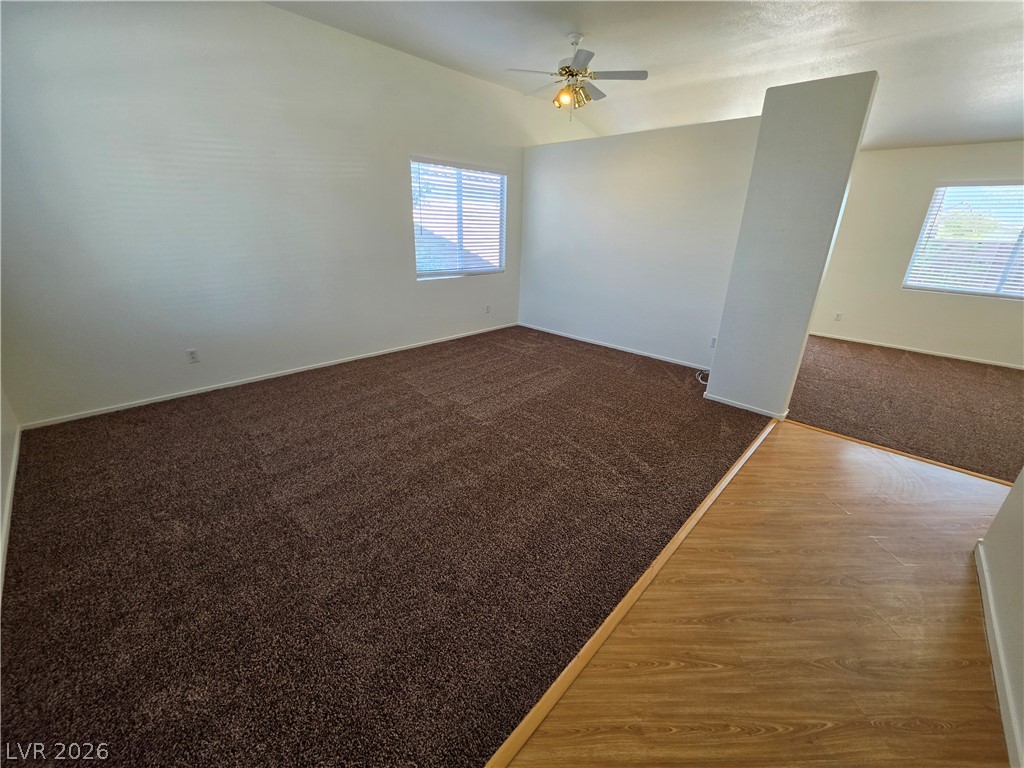 1154 Point Success Avenue Henderson, NV 89014 - Photo 8 of 26 A versatile living area features vaulted ceilings and ample natural light, with soft carpeting transitioning to wood flooring.