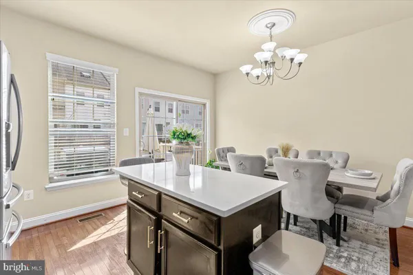 a view of a dining room with furniture a chandelier and wooden floor