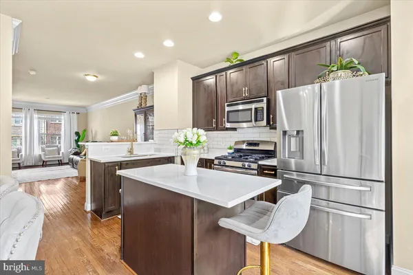 a kitchen with kitchen island a counter top space cabinets and stainless steel appliances