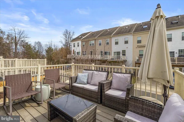 a roof deck with couches and wooden floor