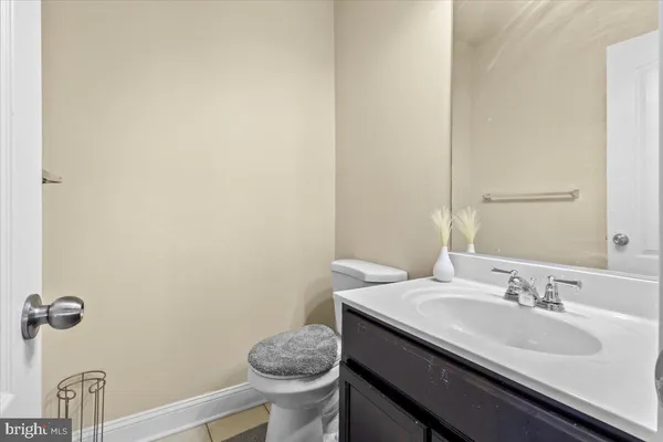 a bathroom with a granite countertop sink and a toilet