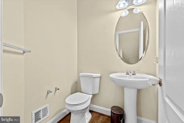 a bathroom with a sink toilet and a mirror