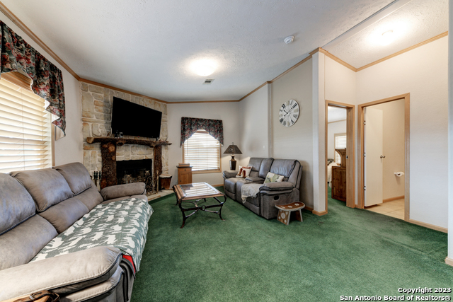 649 Rocky Hill Road Junction, TX 76849 - Photo 10 of 51 a living room with furniture fireplace and a flat screen tv