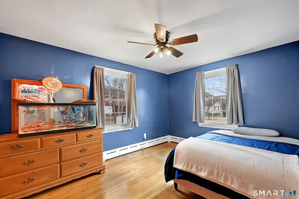 a bedroom with a bed and wooden floor