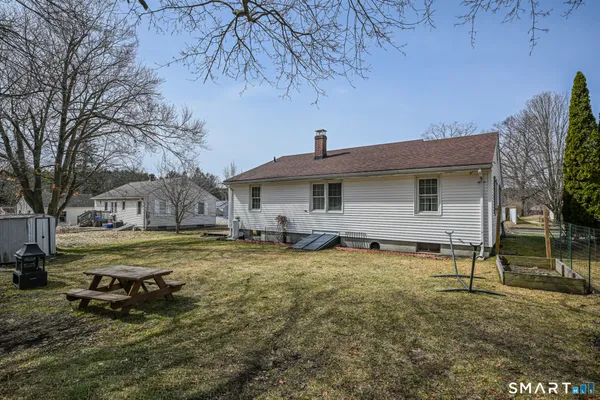 a view of a house with a yard and large tree