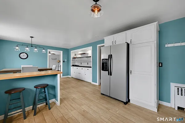 a kitchen with stainless steel appliances a refrigerator and wooden floor