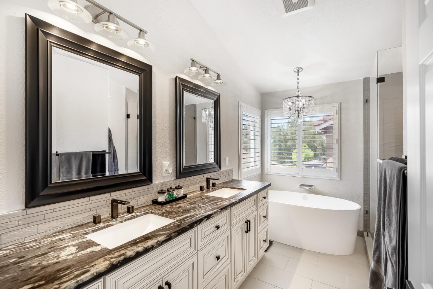 1170 Schoolhouse Road San Jose, CA 95138 - Photo 20 of 35 a bathroom with double vanity sinks a large mirror and a bathtub