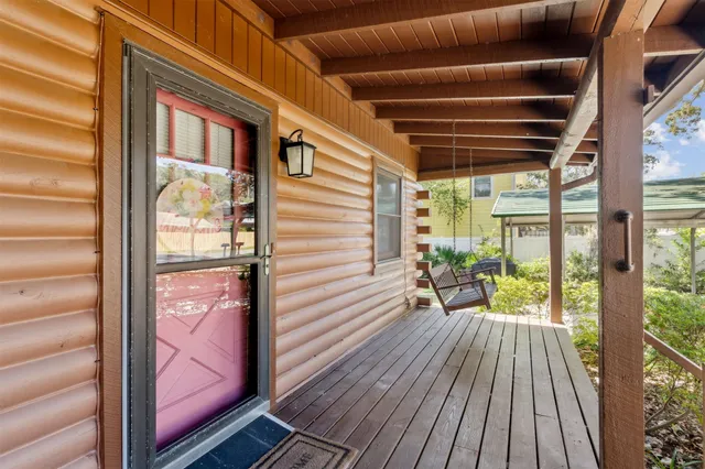 a view of a balcony with chairs and wooden floor