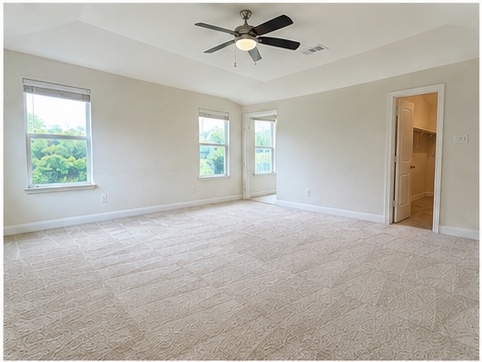 2101 Split Diamond Way, Unit 40 Round Rock, TX 78664 - Photo 20 of 32 A spacious primary bedroom features a ceiling fan, plush carpeting, and abundant natural light from multiple windows.