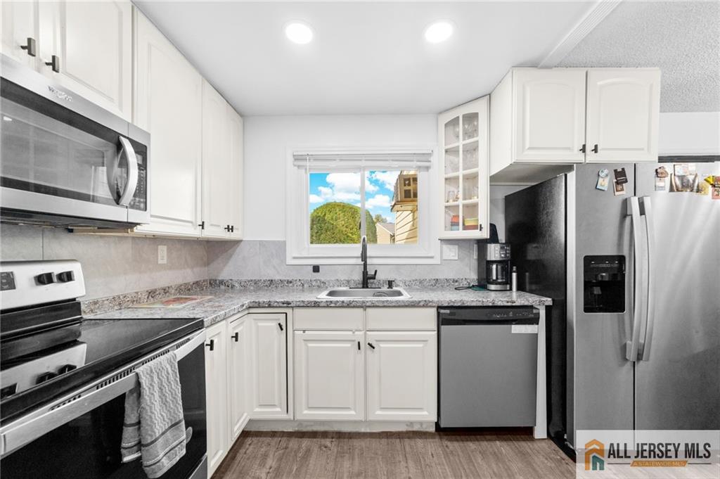 25C Pitman Road, Unit B Monroe Township, NJ 08831 - Photo 13 of 29 a kitchen with a sink stove and refrigerator