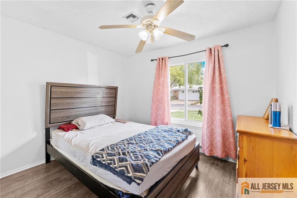 25C Pitman Road, Unit B Monroe Township, NJ 08831 - Photo 19 of 29 a bedroom with a bed and a chandelier