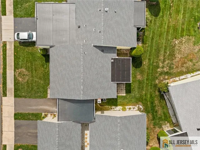 an aerial view of residential houses with outdoor space and parking
