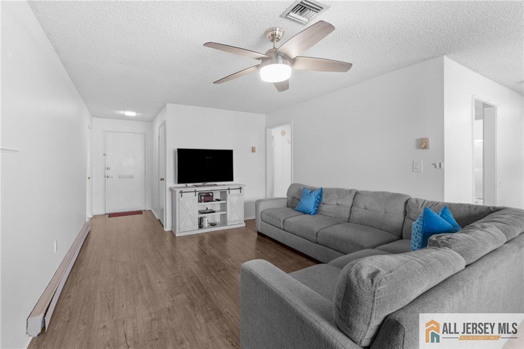 25C Pitman Road, Unit B Monroe Township, NJ 08831 - Photo 6 of 29 a living room with furniture and a flat screen tv