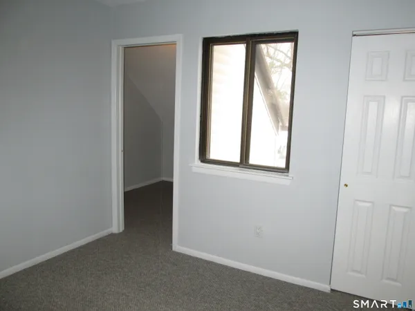 an empty room with windows and closet
