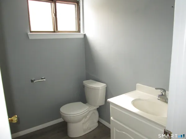 a white toilet sitting next to a white sink and vanity