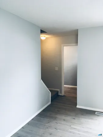 an empty room with wooden floor and entrance
