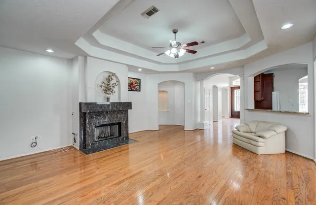 a view of a livingroom with furniture a ceiling fan and wooden floor
