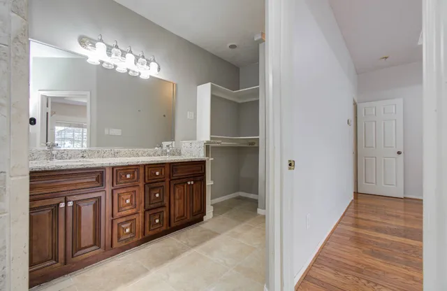 a spacious bathroom with a granite countertop sink a mirror and a shower