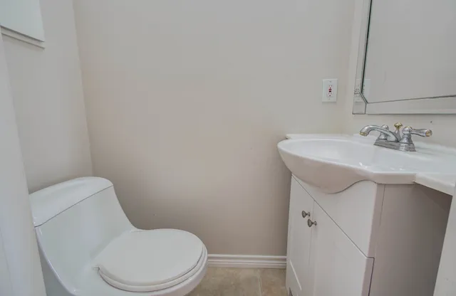 a white toilet sitting next to a bathroom sink