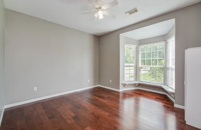 wooden floor in an empty room with a window