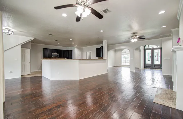 a view of an empty room with window and wooden floor
