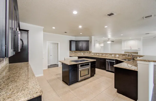 a kitchen with granite countertop a sink and stove