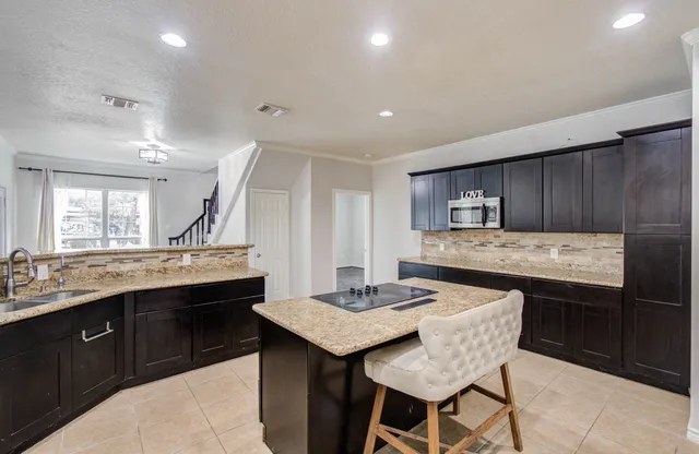 a view of an empty room with wooden floor and a ceiling fan