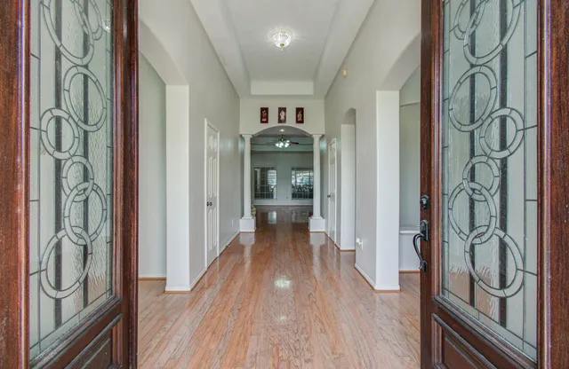 a view of a hallway with wooden floor and front door