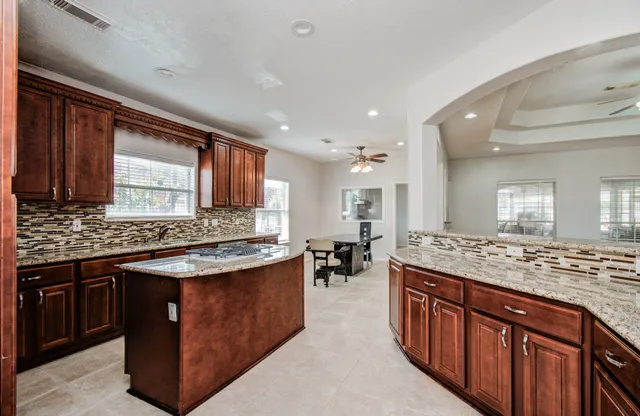 a kitchen with stainless steel appliances granite countertop wooden cabinets and sink