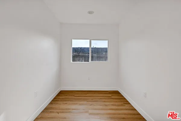 a view of a room with wooden floor and window
